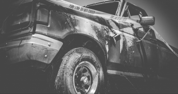 Ein Kfz-Sachverst&auml;ndiger begutachtet die Ladefl&auml;che und das Heck eines besch&auml;digten Pickup-Trucks